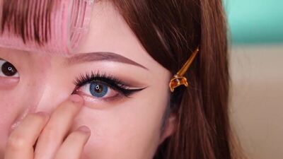 Азиатка показывает чудеса макияжа.