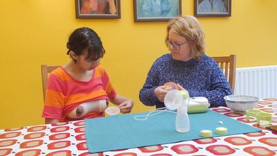 Старуха учит молодую женщину качать грудное молоко